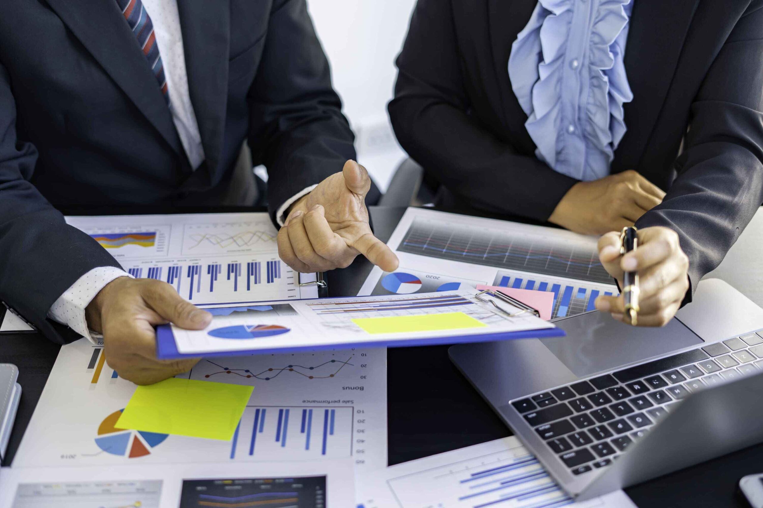 Two professionals in business attire discussing bookkeeping strategies at a desk