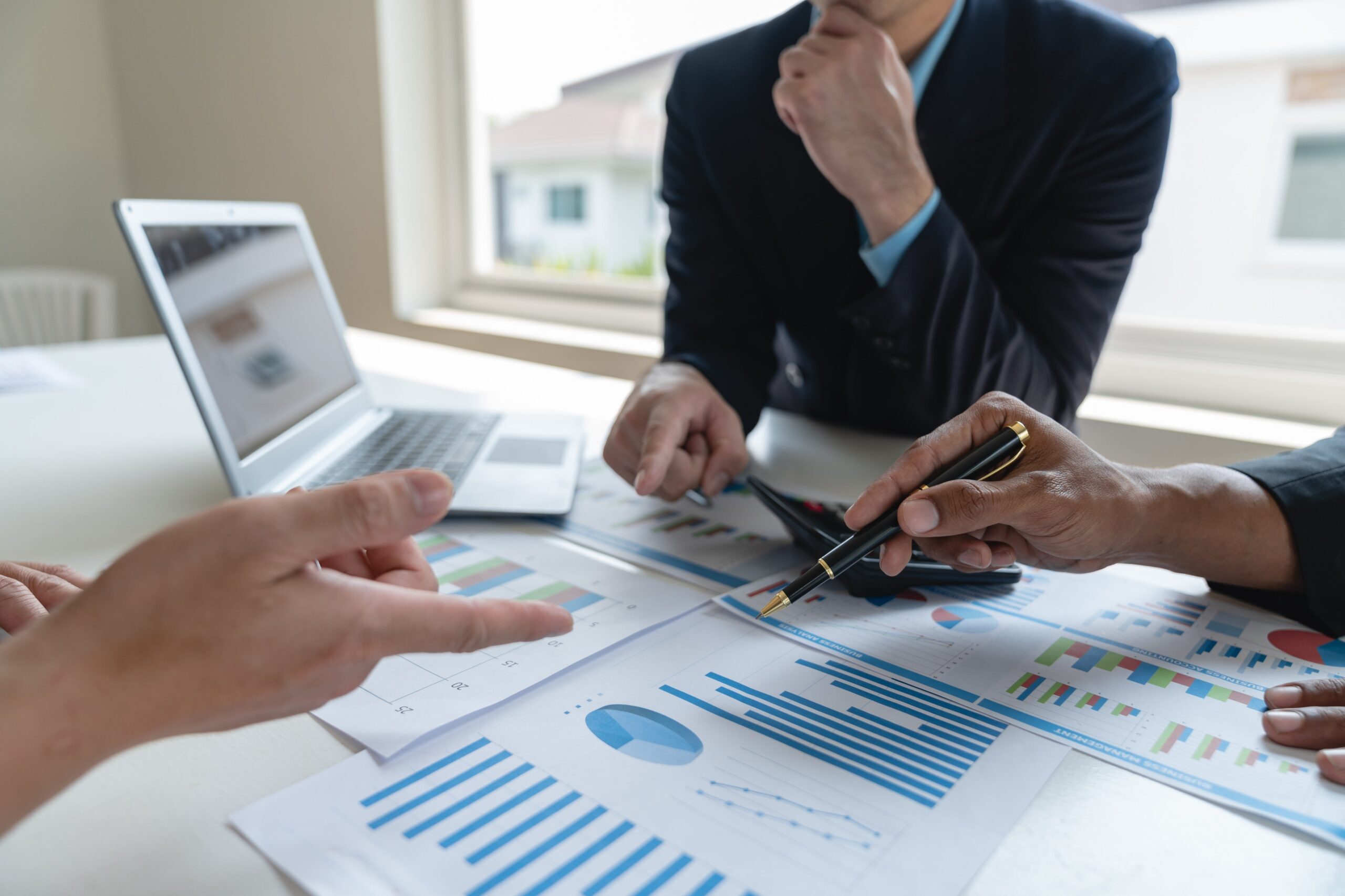 Business professionals analyzing financial graphs and charts during a forensic accounting meeting.