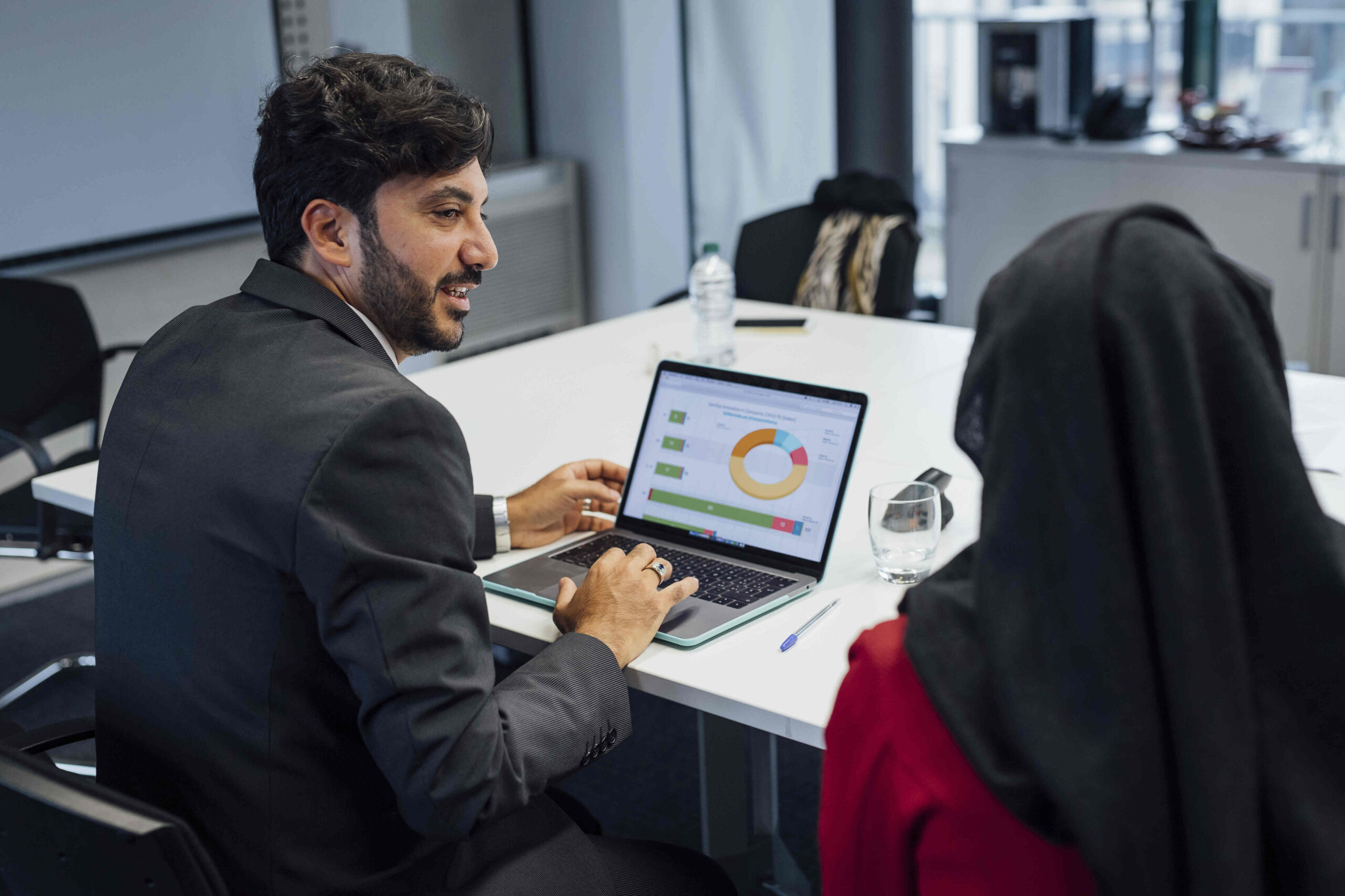 Male accountant presenting financial reports on a laptop to a client in the UAE office